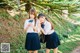 Two young women in school uniforms posing for a picture.