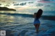 A woman in a blue bathing suit standing in the ocean.