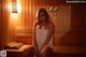 A woman sitting in a sauna with a towel wrapped around her body.