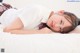 A young woman laying on a bed wearing a school uniform.