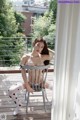 A woman sitting on a chair on a balcony.