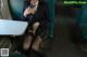 A woman in a school uniform is sitting on a train.